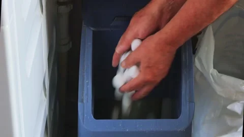 Close-up of a man filling a water softner with salt tablets in a utility room Stock Footage 339192070