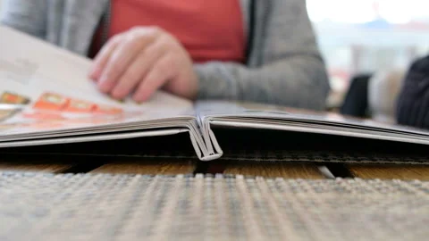 Close up of man finger with menu choosing dishes at restaurant Stock Footage 107368860