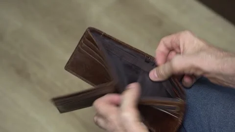 Close-up of man on floor opening empty brown wallet Stock Footage 307402870