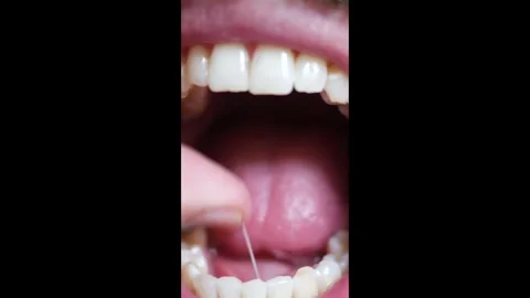 Close up of Man Flossing Teeth - Vertical Re-Render Stock Footage 325759486