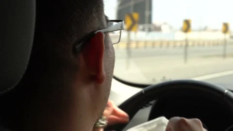 Close-up of a man with glasses putting on a mask for covid-19 while driving a Stock-Footage 155824936