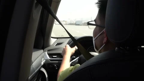 Close-up of a man with glasses taking off his mask for covid-19 and driving his Video stock 155825117