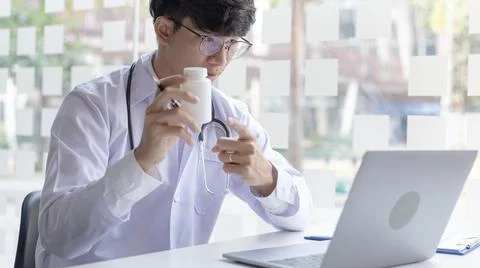 Close-up of a man with glasses using a laptop, Doctor is talking and giving a Stock Photos