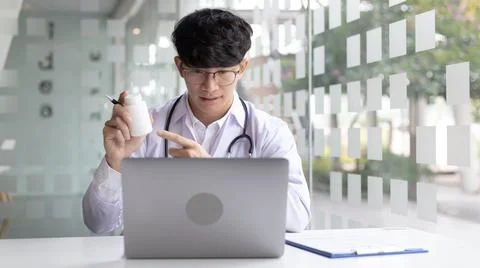 Close-up of a man with glasses using a laptop, Doctor is talking and giving a Stock Photos