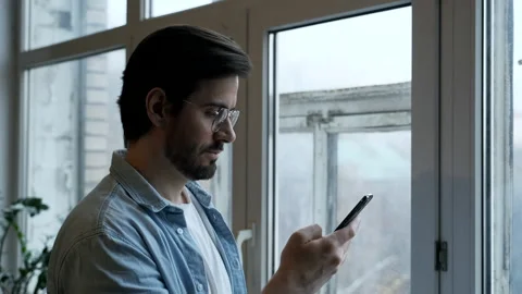 Close-Up Of a man with Glasses Using a Smartphone Online Stock Footage 144685409