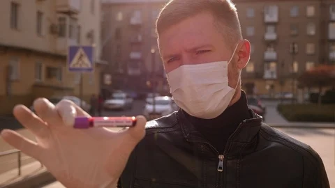 Close-up of man in gloves holding a test tube with a blood test for coronavirus. Stock Footage 128317843