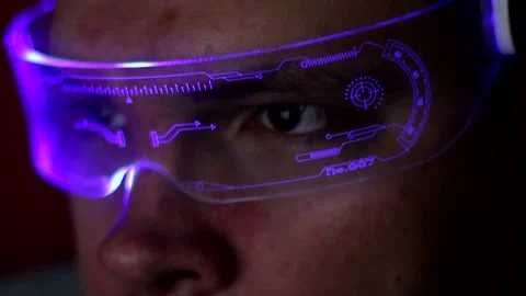 A close-up of a man with glowing technology glasses working on a computer Stockbeeldmateriaal 333706943