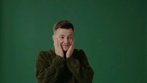 Close up of a man on a green background wearing a cap and blowing his hands. Stock-Footage 226219353