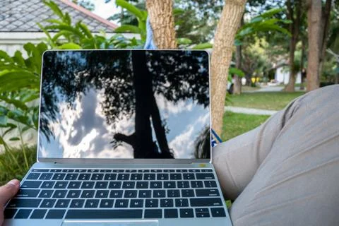 Close up man in a hammock with laptop computer on vacation day relax time Stock Photos