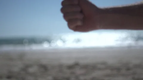 Close man hand at the beach, holding beach sand and open slowly Stock Footage 100165396
