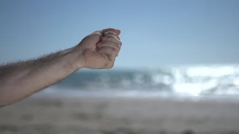 Close man hand at the beach, holding beach sand and open slowly Stock Footage 100166311