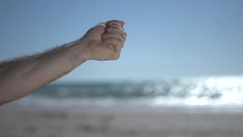 Close man hand at the beach, holding beach sand and open slowly Stock Footage 100166401