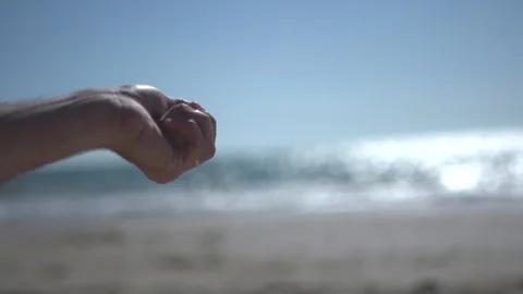 Close man hand at the beach, holding beach sand and open slowly Stock Footage 100166738