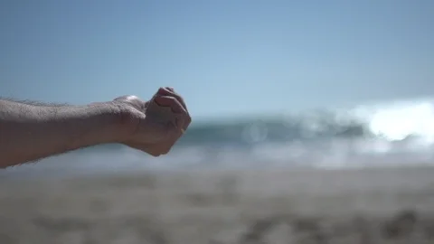 Close man hand at the beach, holding beach sand and open slowly Stock Footage 100166792