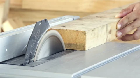 Close-up man hand carpenter sawing wooden with electric saw table machine Stock Footage 138795898