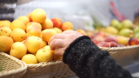 Close up of man hand. He take apricot in mall from box. Modern supermarket Stock Footage 112286231