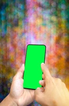 Close up man hand hold using smart phone on colorful bokeh background. Stock-Fotos