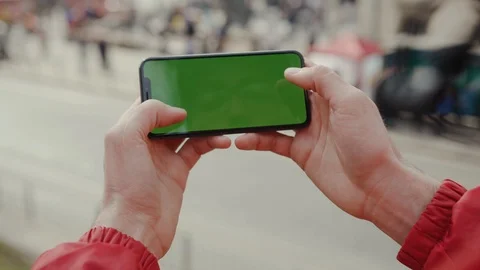 Close up man hand holding and touching phone with green screen horizontal Stock Footage 106158653
