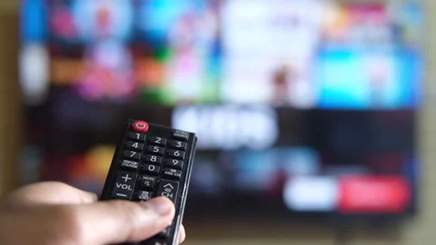 Close up of man hand holding tv remote and watching tv Stock Footage 149754539