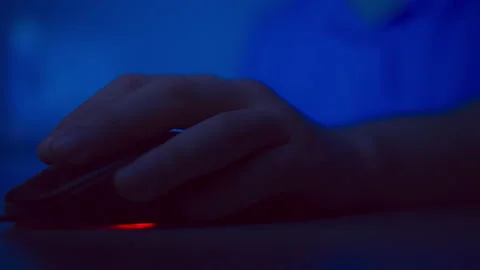 Close up man hand holds a computer mouse, multicolored lighting Stock Footage 150459019