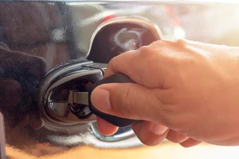Close up man hand inserting a key into the door lock  a car Stock Photos