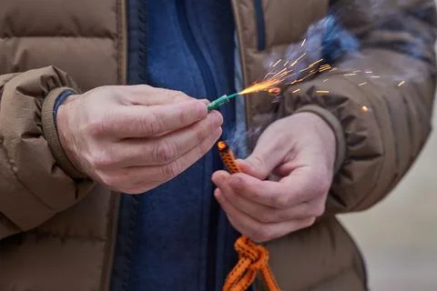 Close up of man hand lighting up a firecrackers with wick Stock Photos