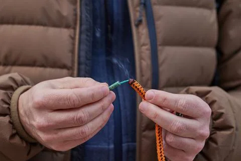 Close up of man hand lighting up a firecrackers with wick Stock Photos