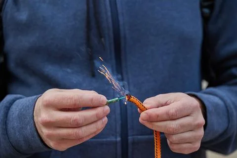 Close up of man hand lighting up a firecrackers with wick Stock Photos