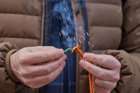 Close up of man hand lighting up a firecrackers with wick Stock Photos