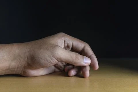 Close up of man hand lying on table. concept of depressed or frustrated man f Stock Photos