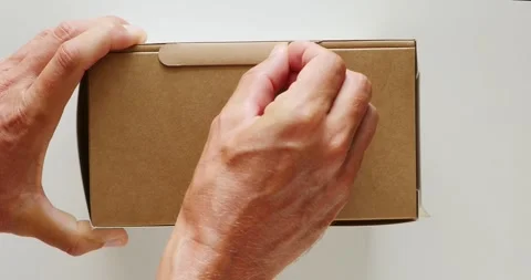 Close-up. Man hand opens new brown cardboard box with new tech. Stock Footage 254747741