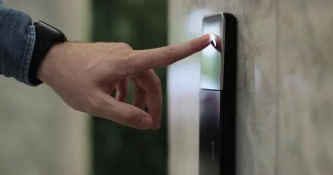 Close-up of man hand presses the elevator call button. Elevator door control Stockfoto's