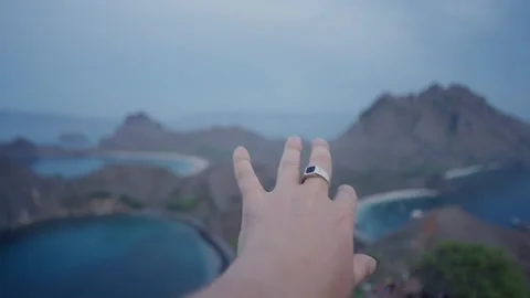 Close up man hand with ring in sunrise in komodo island background Video stock 261120594
