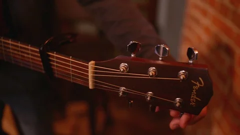 Close-up a man hand sets up a Guitar Strings to play in a Restaurant Evening Stock Footage 84633626