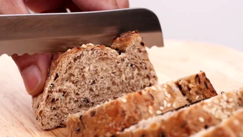Close-up man hand slicing or cutting fresh brown bread with bread knife Stock Footage 170602461