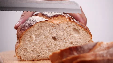Close-up man hand slicing or cutting fresh brown bread with bread knife Vídeo Stock 170609679