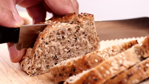 Close-up man hand slicing or cutting fresh brown bread with bread knife Stock Footage 170612799