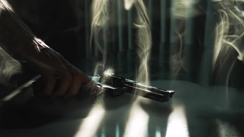 Close up man hand taking revolver gun from the table. Backlight by dramatic Stock Footage 292949291