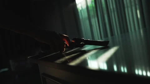 Close up man hand taking revolver gun from the table backlight by dramatic Stock Footage 294151714