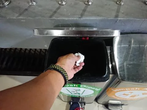 Close up Man hand throwing the trash to bin Stock Photos