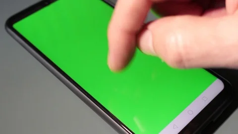 Close-up, man hand typing on smartphone with green screen and green background Stock Footage 126407955