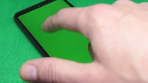 Close-up, man hand typing on smartphone with green screen and green background Stock Footage 126409253