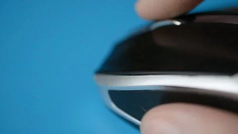 Close-up of a man hand uses white wireless mouse on blue background Stock Footage 119287978