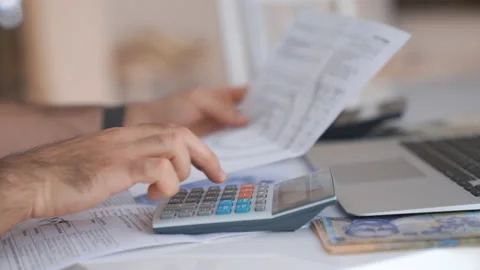 Close up man hand using calculator, checking bills, pay taxes, In the living Vídeo Stock 160189872