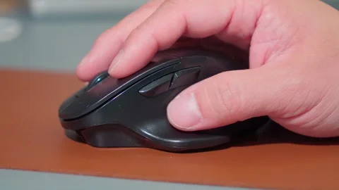 Close Up Man Hand Using Ergonomic Wireless Mouse at Office Desk Stock Footage 341919458