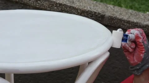 Close up of man hand using roller while painting wooden table outdoors. Stock Footage 327654588