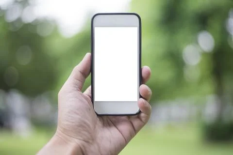 Close up man hand using smartphone in green park, Mockup of blank screen of.. Stock Photos