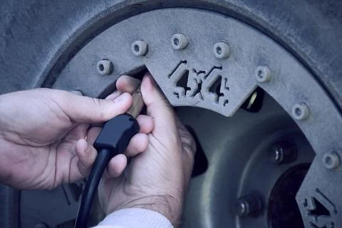 Close up man hands checking car tyre pressure measurement. Stock Photos