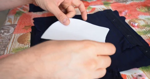 Close up on man hands cutting sewing pattern to create a homemade face mask Stock Footage 129363768