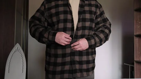 Close-up of a man hands fastening buttons of shirt at home. Vídeo Stock 331423537